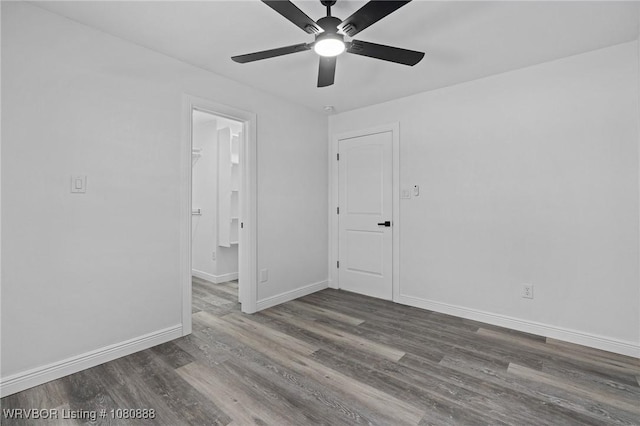 empty room featuring a ceiling fan, wood finished floors, and baseboards