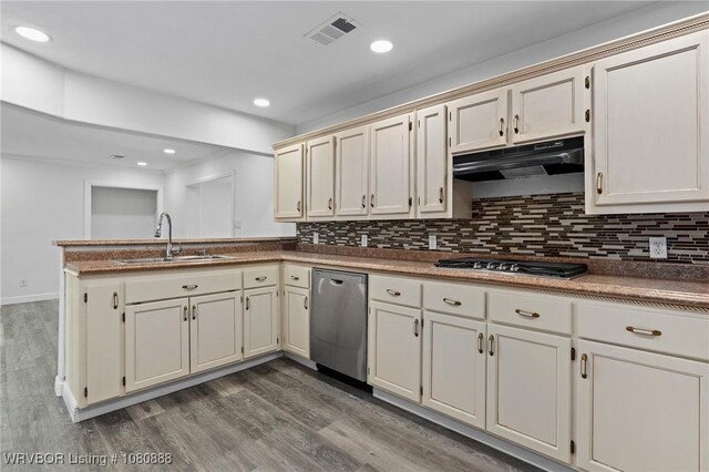 kitchen with a sink, under cabinet range hood, stainless steel appliances, a peninsula, and wood finished floors