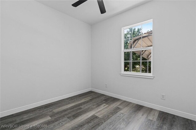 spare room featuring dark wood finished floors, baseboards, and ceiling fan