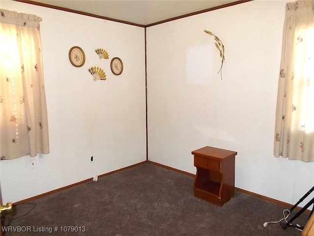 unfurnished room featuring crown molding and dark carpet