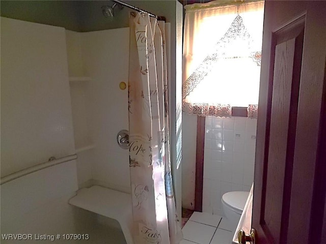 bathroom with tile walls and toilet