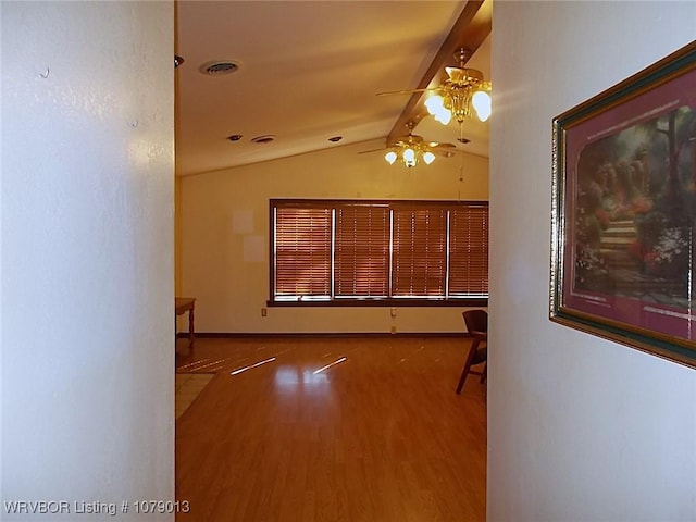 spare room featuring lofted ceiling with beams, ceiling fan, and hardwood / wood-style floors