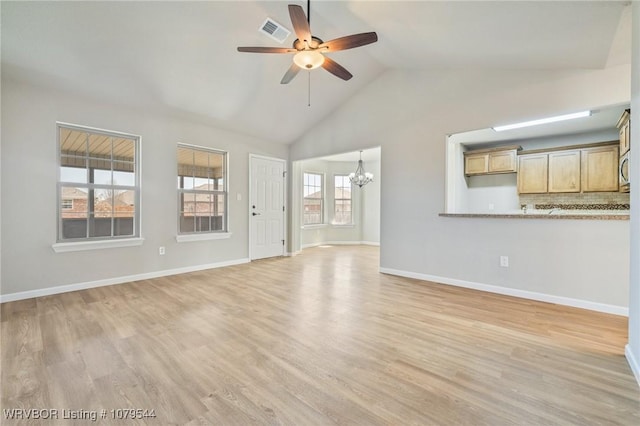 unfurnished living room featuring ceiling fan with notable chandelier, visible vents, light wood finished floors, and baseboards