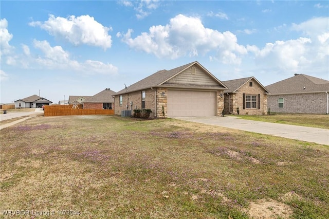 ranch-style home with a front yard, central AC unit, fence, driveway, and a garage