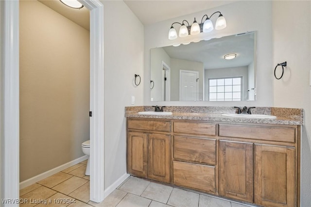 bathroom featuring tile patterned flooring, double vanity, toilet, and a sink