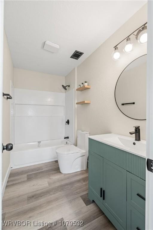 full bath with visible vents, toilet, wood finished floors,  shower combination, and vanity