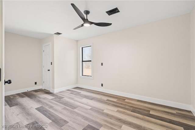 empty room with visible vents, baseboards, and wood finished floors