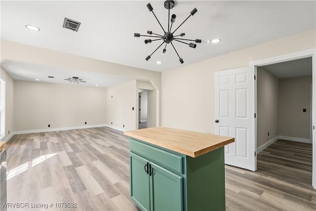 kitchen featuring visible vents, butcher block counters, light wood-style floors, and green cabinetry