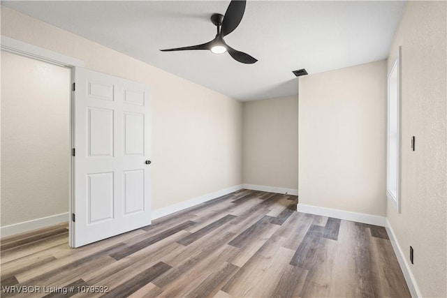 spare room with visible vents, baseboards, and wood finished floors