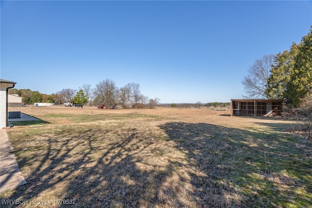 view of yard featuring a rural view and an outdoor structure