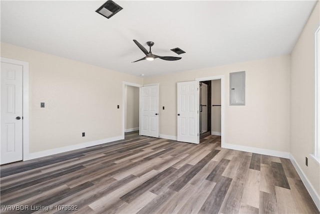 unfurnished bedroom with electric panel, wood finished floors, a closet, baseboards, and ceiling fan