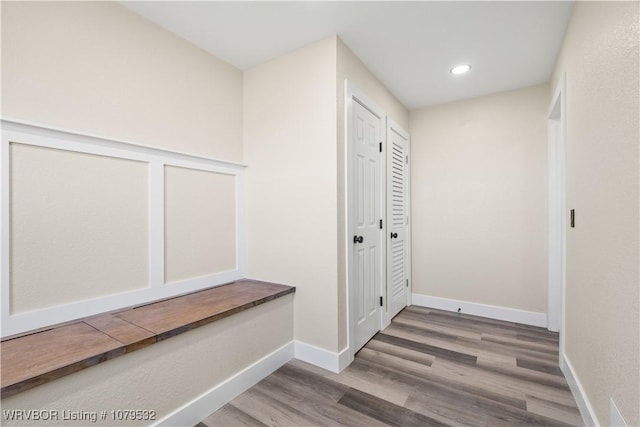 corridor featuring recessed lighting, wood finished floors, and baseboards