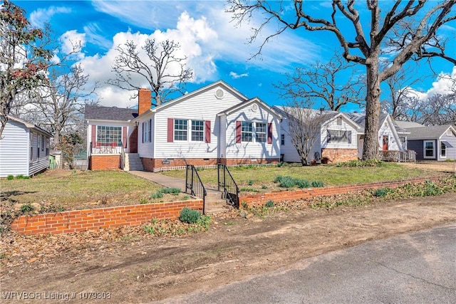 view of front of home with a front lawn, crawl space, and a chimney