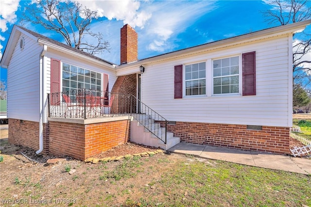 view of front of property with crawl space and a chimney