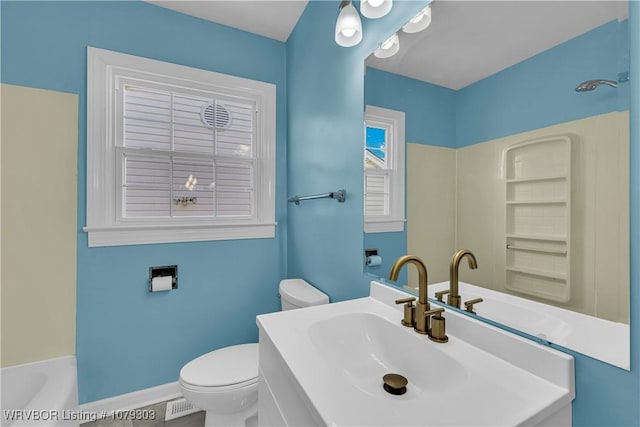 bathroom with a bathing tub, a sink, toilet, and baseboards