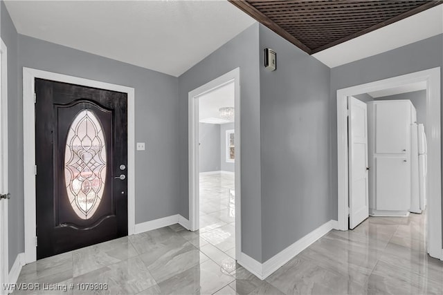 entrance foyer with marble finish floor and baseboards