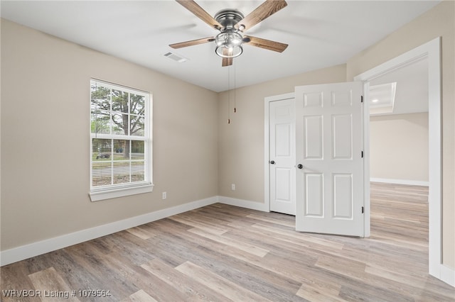 unfurnished bedroom with baseboards, visible vents, light wood-style floors, and ceiling fan