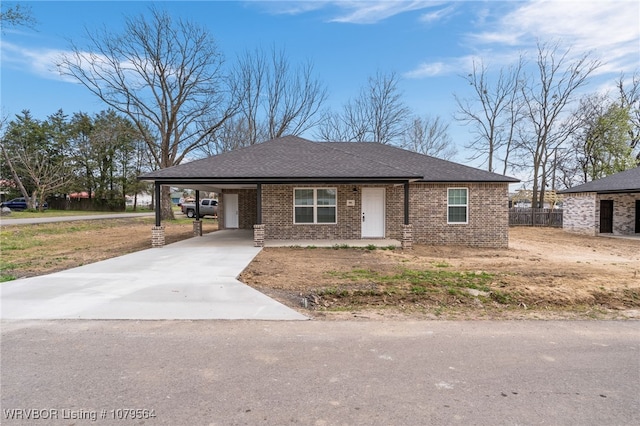view of front of property featuring a carport, brick siding, and concrete driveway