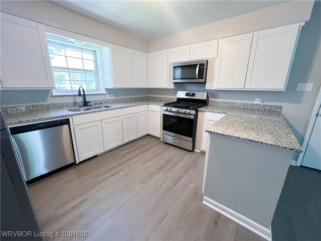 120 W Gary St, Greenwood, AR 72936 - kitchen with appliances with stainless steel finishes, a sink, light wood-type flooring, and white cabinetry