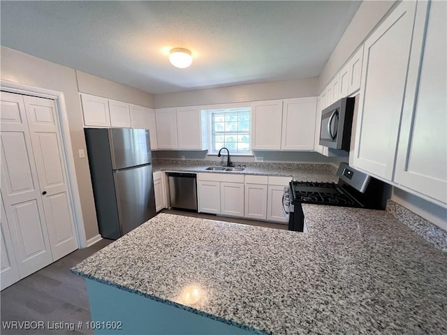 120 W Gary St, Greenwood, AR 72936 - kitchen featuring stainless steel appliances, a sink, light stone counters, white cabinets, and a peninsula