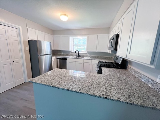 120 W Gary St, Greenwood, AR 72936 - kitchen featuring stainless steel appliances, a sink, light stone countertops, white cabinets, and a peninsula