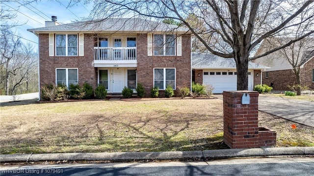 view of front of home featuring a balcony, driveway, an attached garage, a chimney, and brick siding