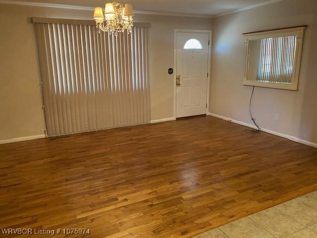 entryway with hardwood / wood-style flooring, a notable chandelier, and ornamental molding