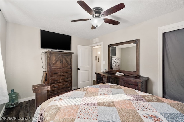 bedroom with a textured ceiling, ceiling fan, and dark hardwood / wood-style floors