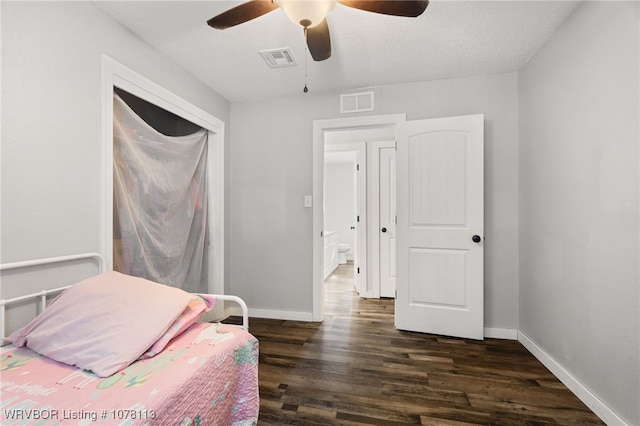 bedroom with a textured ceiling, ceiling fan, and dark wood-type flooring