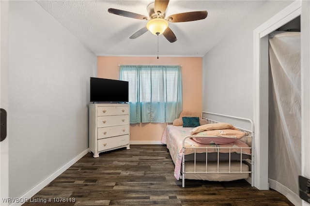 bedroom featuring a textured ceiling, dark hardwood / wood-style floors, and ceiling fan