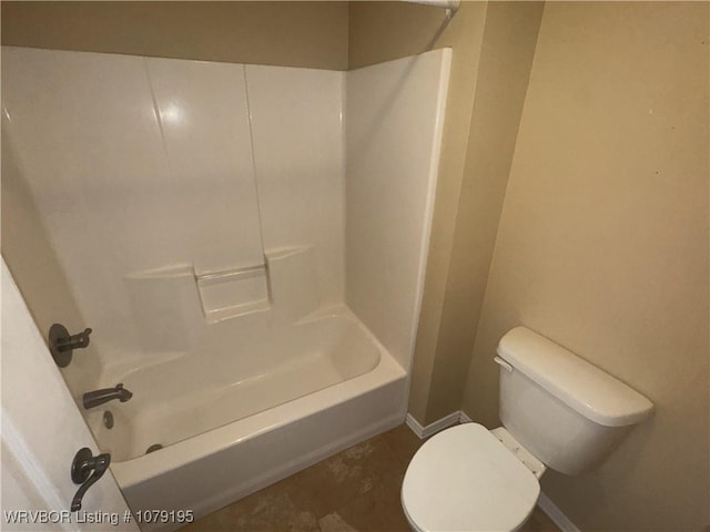 bathroom with toilet, shower / tub combination, and baseboards