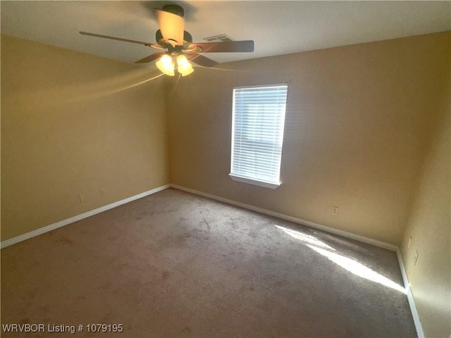 carpeted empty room featuring baseboards, visible vents, and a ceiling fan