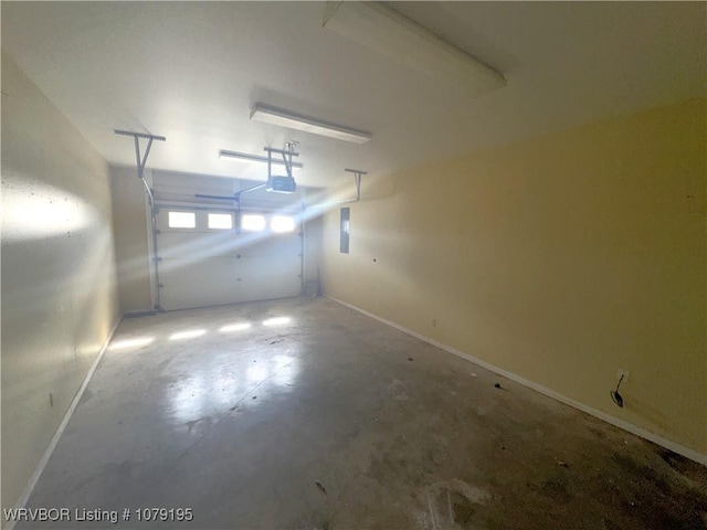 garage featuring baseboards, electric panel, and a garage door opener