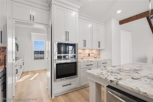 kitchen with white cabinetry, appliances with stainless steel finishes, decorative backsplash, light stone counters, and beamed ceiling