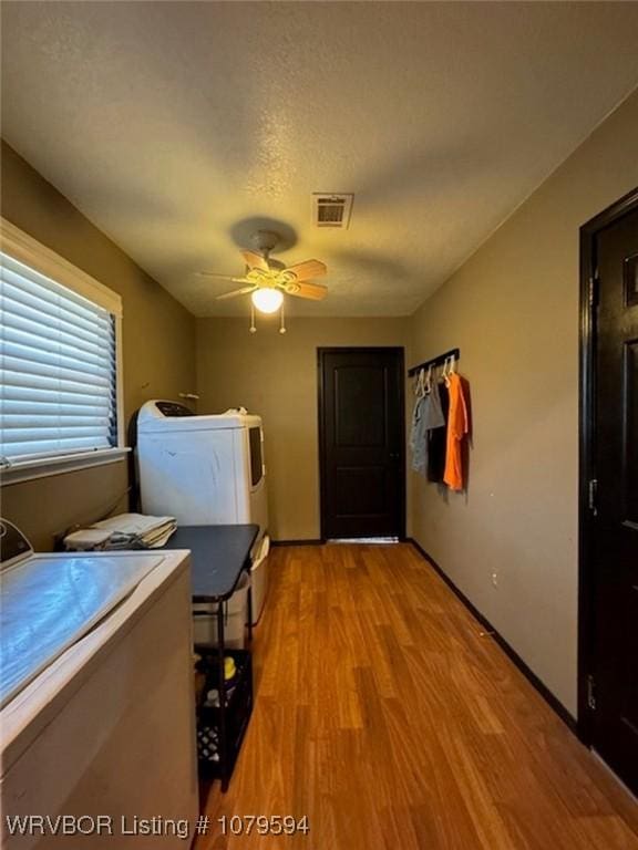 laundry area featuring a ceiling fan, visible vents, light wood finished floors, laundry area, and washer and dryer