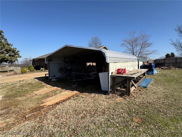 view of outdoor structure featuring fence and driveway