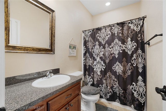 bathroom with toilet, tile patterned flooring, and vanity