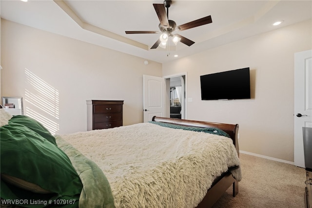 carpeted bedroom featuring a ceiling fan, recessed lighting, a raised ceiling, and baseboards