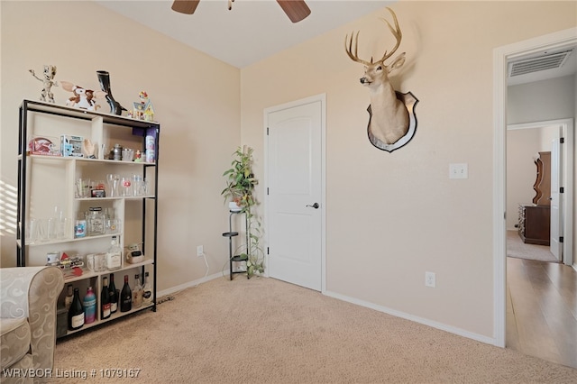 misc room featuring light colored carpet, visible vents, ceiling fan, and baseboards