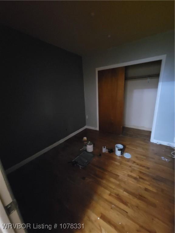 unfurnished bedroom featuring a closet and wood-type flooring