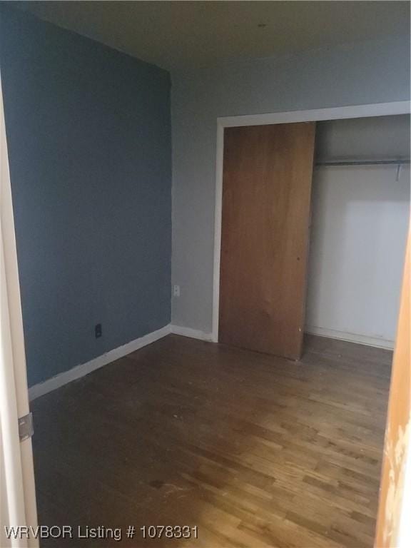 unfurnished bedroom with a closet and hardwood / wood-style floors