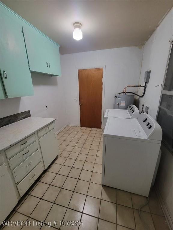 laundry room featuring water heater, cabinets, light tile patterned floors, and washing machine and clothes dryer