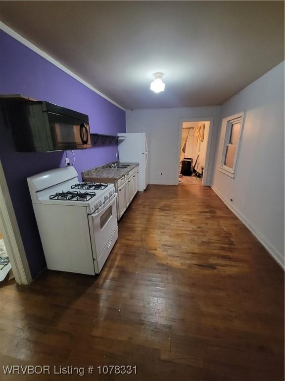 kitchen with white cabinets, dark hardwood / wood-style floors, and white gas range