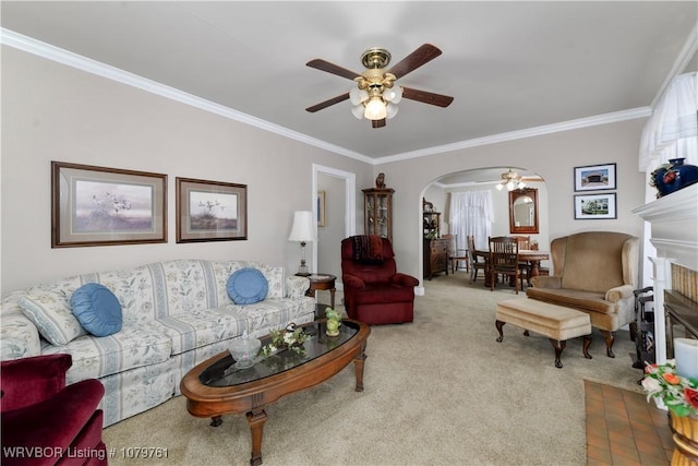 carpeted living area featuring arched walkways, a fireplace, crown molding, and ceiling fan
