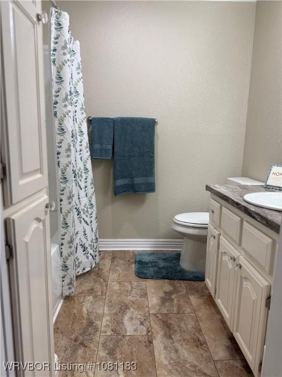 1304 S Elm St, Paris, AR 72855 - bathroom featuring vanity, toilet, shower / bath combo, and baseboards