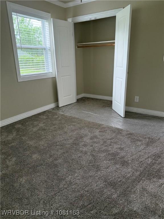1304 S Elm St, Paris, AR 72855 - unfurnished bedroom featuring carpet flooring, baseboards, a closet, and crown molding
