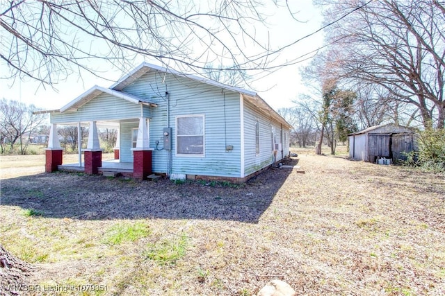 exterior space featuring a porch, crawl space, an outdoor structure, and a storage unit