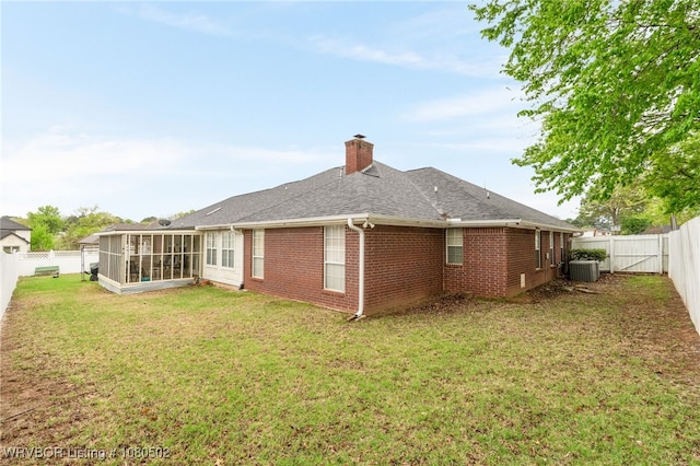 rear view of property with a sunroom, a fenced backyard, and brick siding