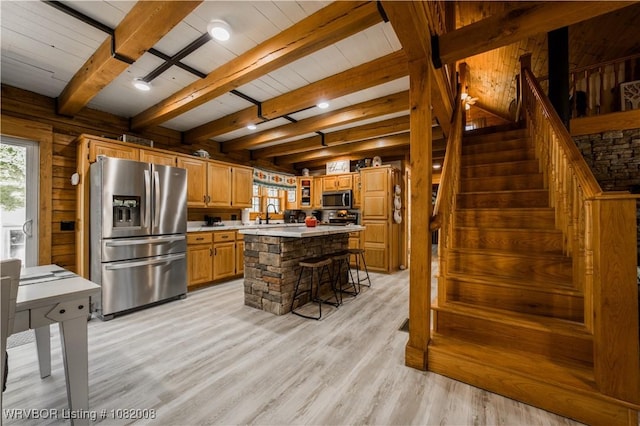 16175 Cove, Prairie Grove, AR 72753 - kitchen with appliances with stainless steel finishes, wooden walls, light countertops, light wood finished floors, and a center island