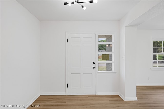 entryway featuring a chandelier and light hardwood / wood-style flooring